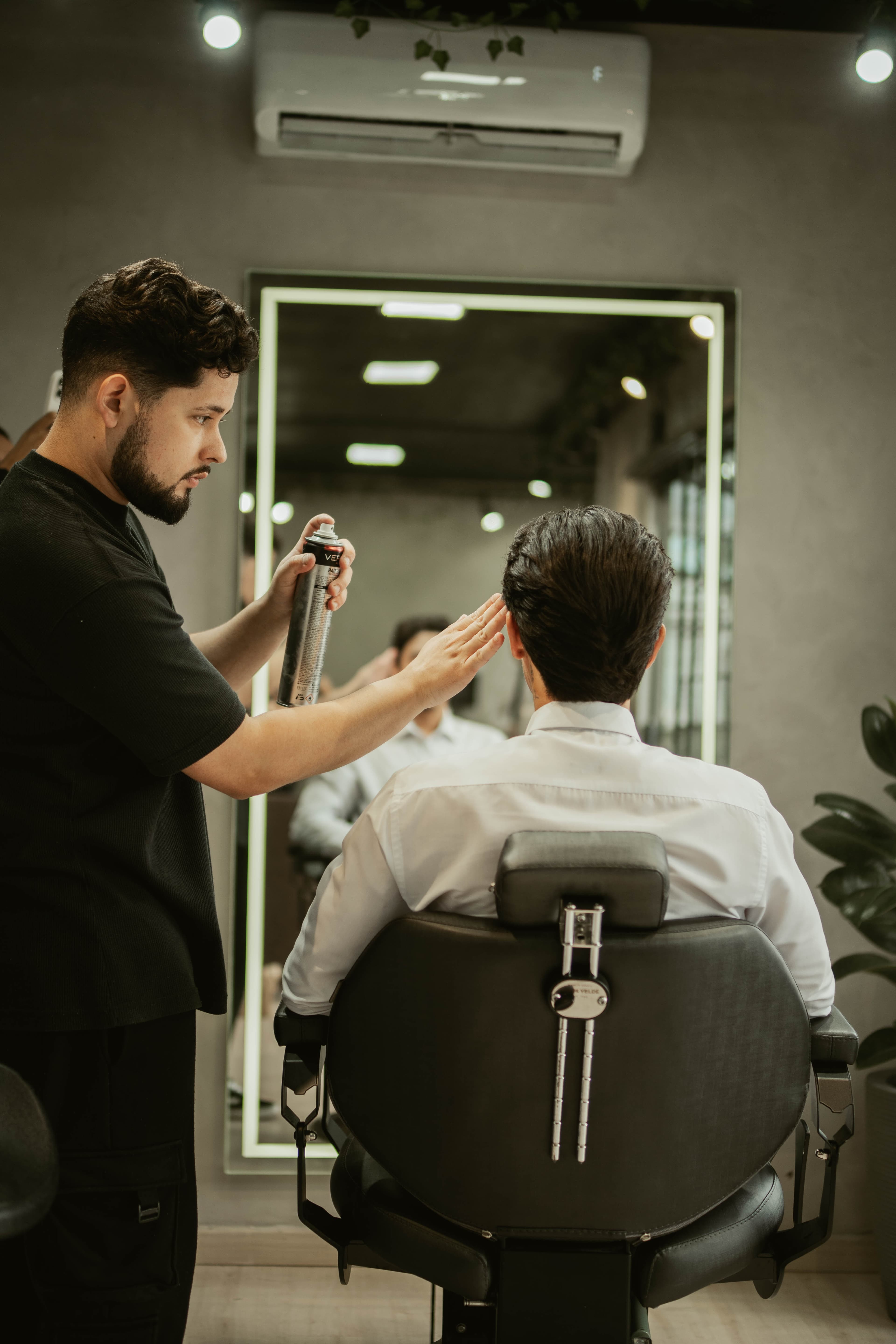 Bruno de Carli finalizando o cabelo de um cliente na D'Carli Barber